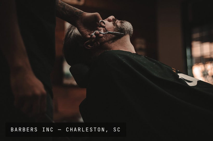 Barber trimming a client's beard with shears